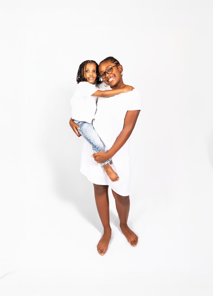 Sweet portrait of a granddaughter holding her baby brother during a family session