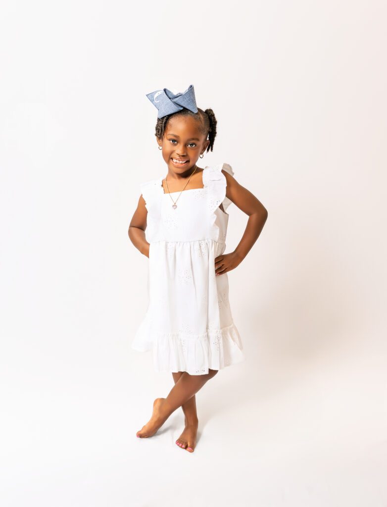 A smiling granddaughter standing proudly during a family portrait session